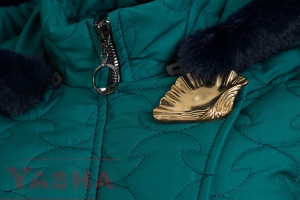 Hood with dark fluffy trim, stand collar and gold-tone decorative accent on a petrol coat